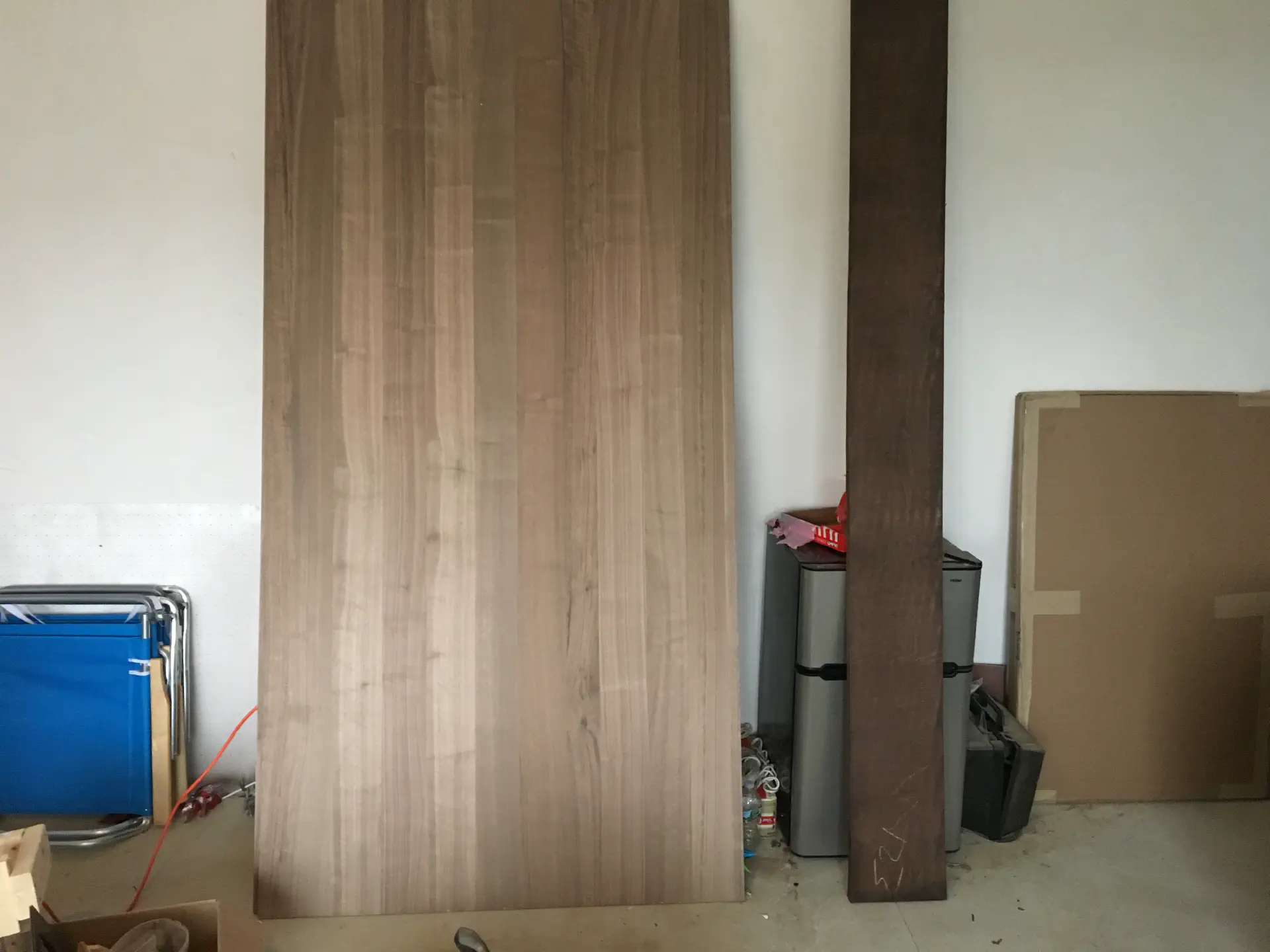 Raw wooden materials like walnut plywood and a board of walnut hardwood