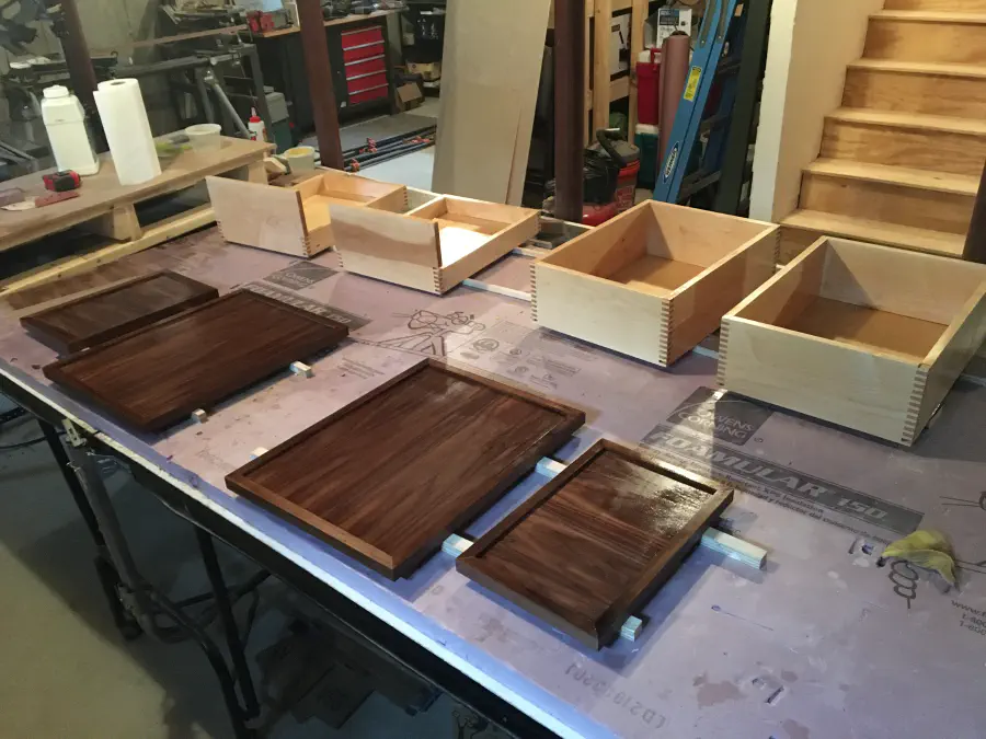 The walnut doors and maple drawers receiving finish