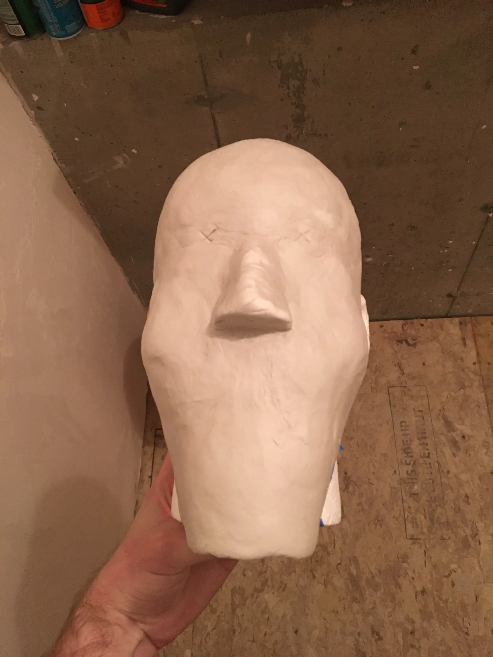 A clay model of a face, with an extended chin section.