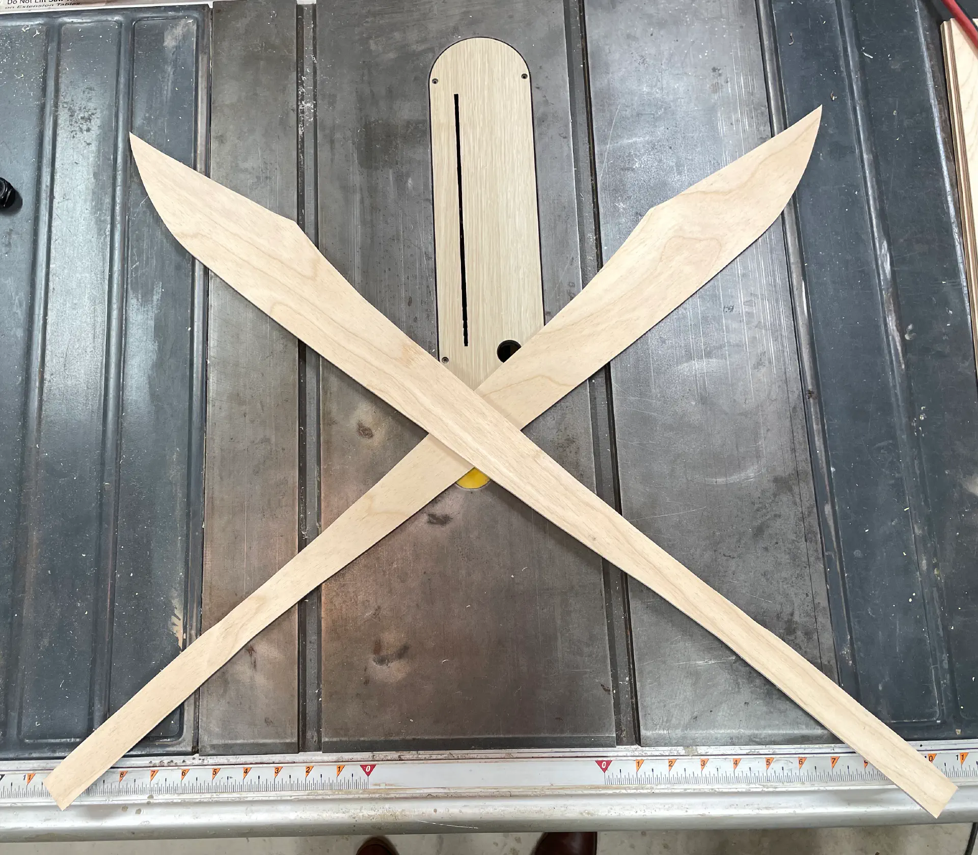 Two crossed swords, cut out of quarter inch plywood.