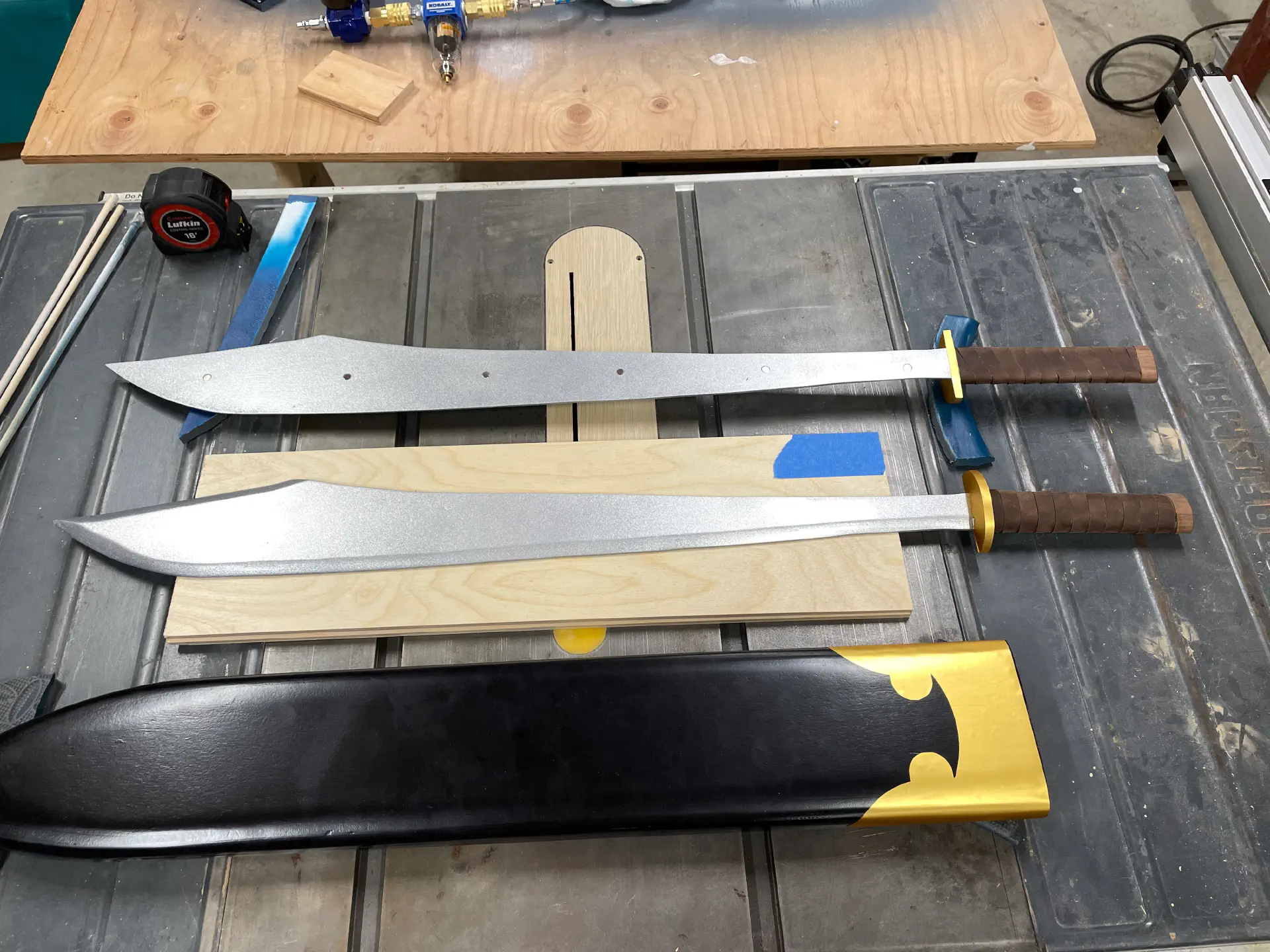 Two swords, with magnetics for securing side-to-side. The hilts are leather wrapped. The guards and sheath are wrapped in gold vinyl.
