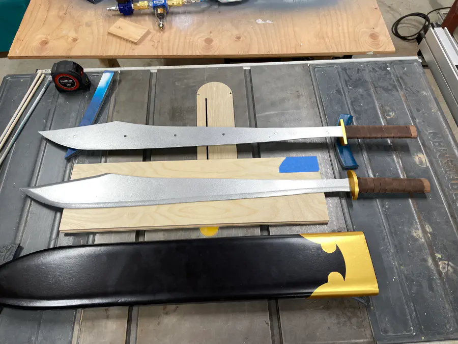 Two swords, with magnetics for securing side-to-side. The hilts are leather wrapped. The guards and sheath are wrapped in gold vinyl.